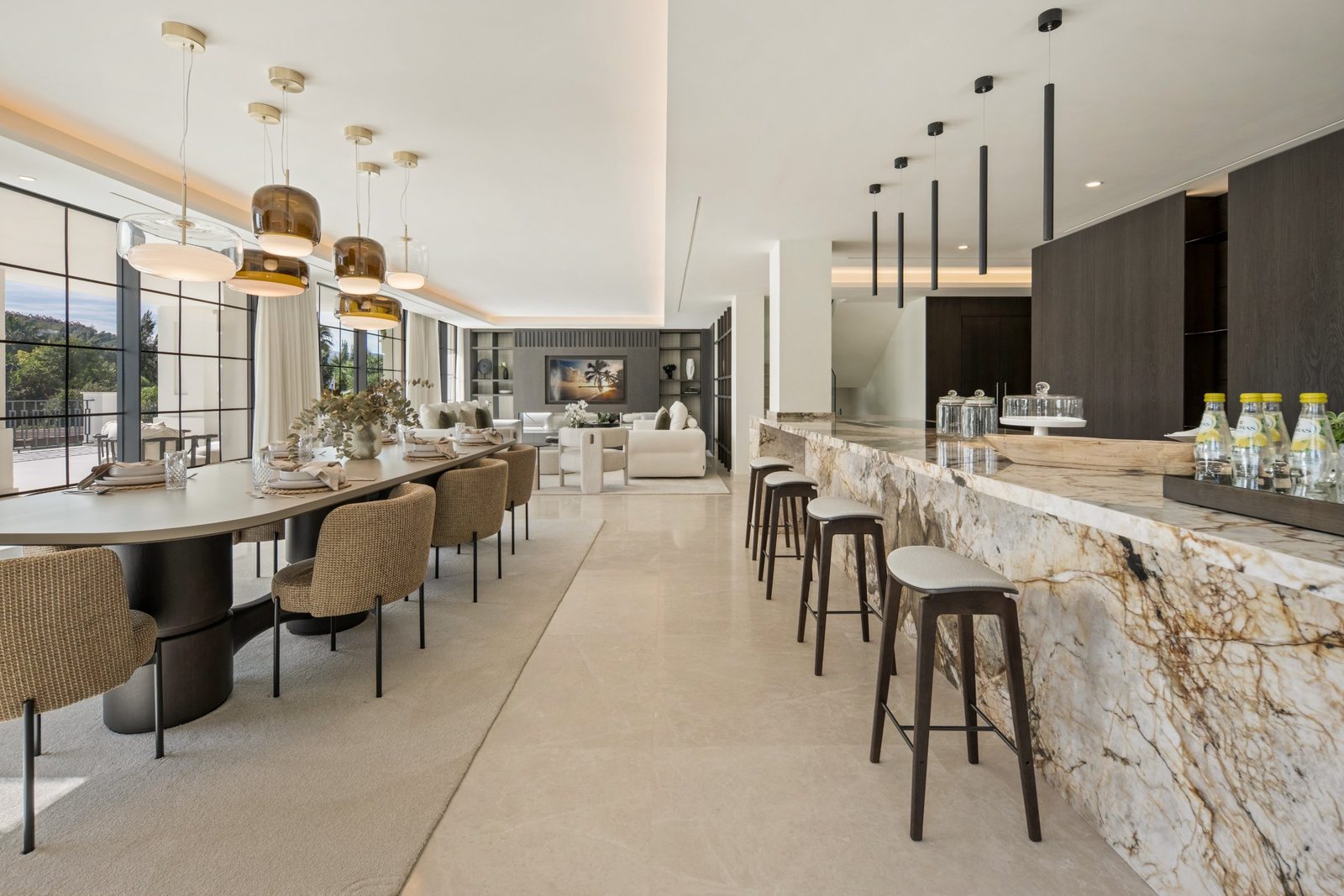 Open-plan dining, living and kitchen area with a marble island of a 6-bedroom villa in Málaga - The Estates