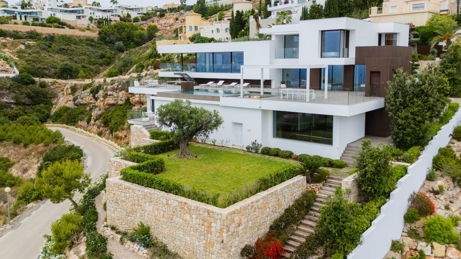 A modern villa with a pool and manicured garden overlooking the sea in Benitachell - The Estates