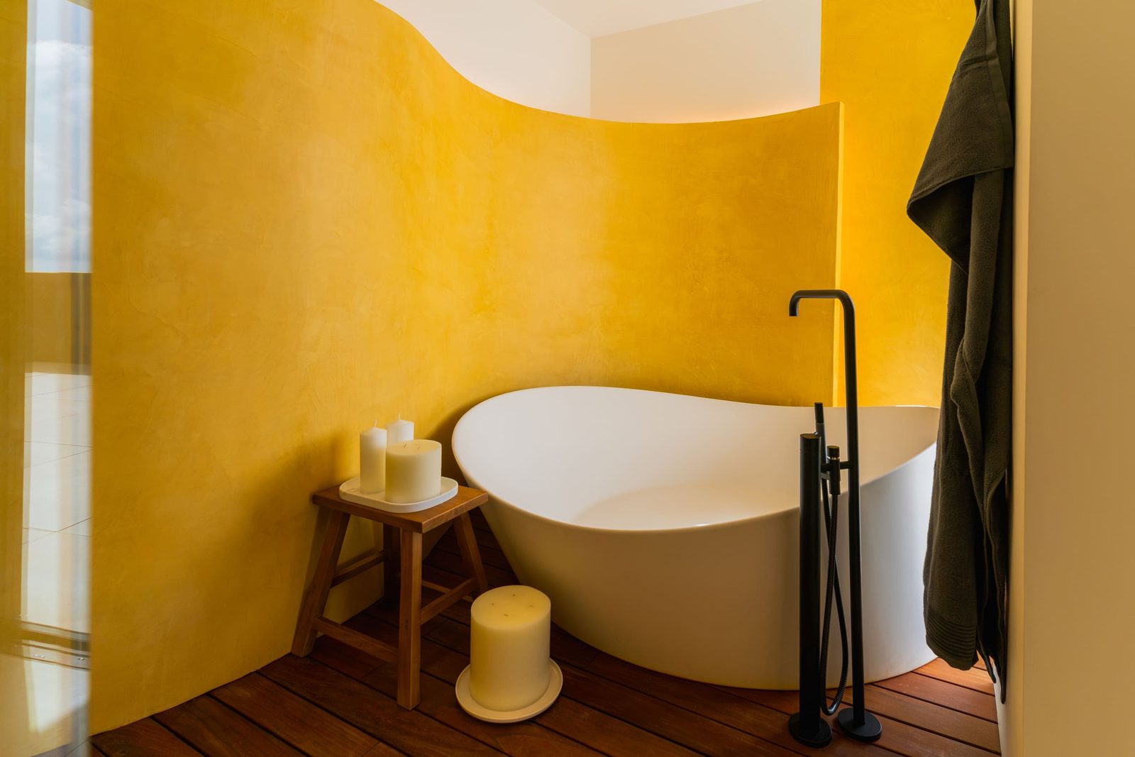 Stylish bathroom with a freestanding tub and warm yellow walls in a 5-bedroom villa in Benitachell - The Estates