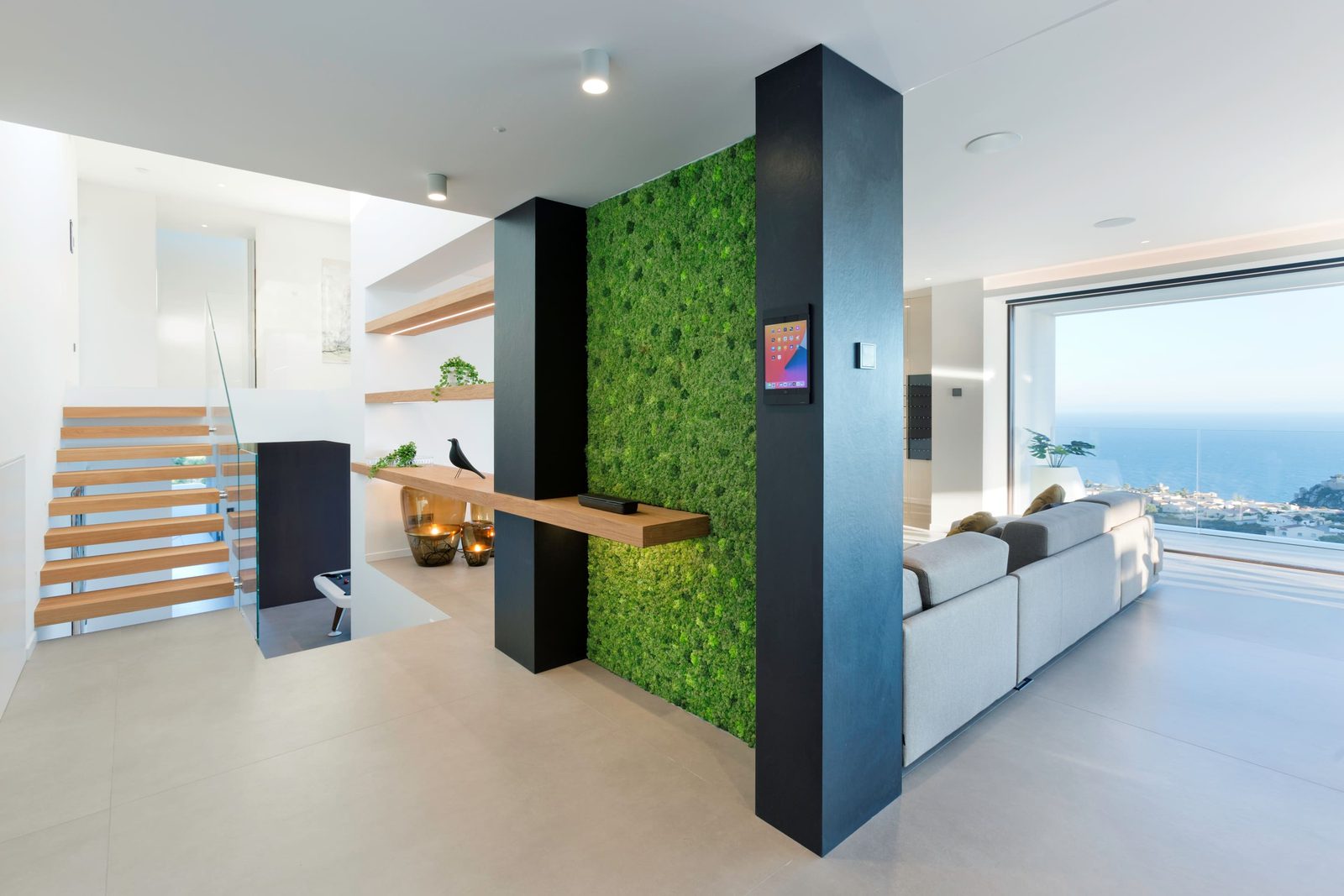Stylish living room with a green wall and sea views in a 5-bedroom villa in Benitachell - The Estates