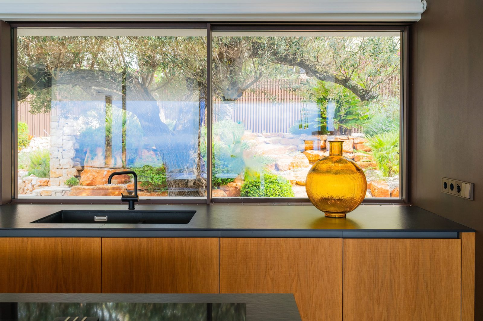 A view of lush greenery through a window in a 5-bedroom villa in Benitachell - The Estates