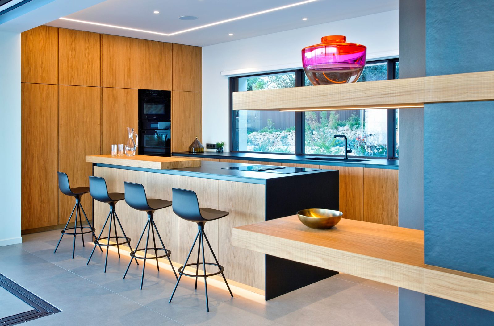 Modern kitchen with island and bar seating in a 5-bedroom villa in Benitachell - The Estates