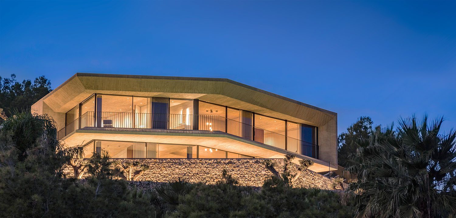 Illuminated modern exterior with terraces and stone landscaping at dusk of a 4-bedroom villa in Benissa - The Estates