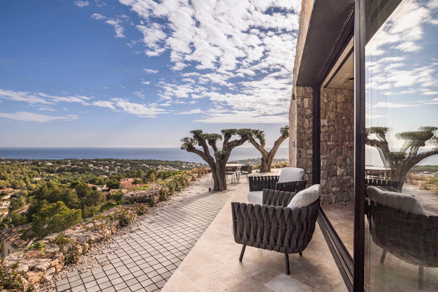 Stone terrace with outdoor seating and panoramic sea views of a 4-bedroom villa in Benissa - The Estates