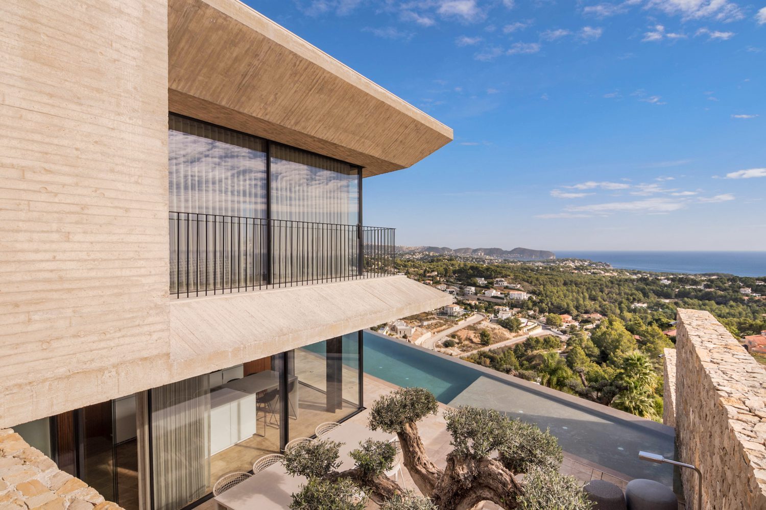 Modern villa exterior with infinity pool and panoramic sea views
