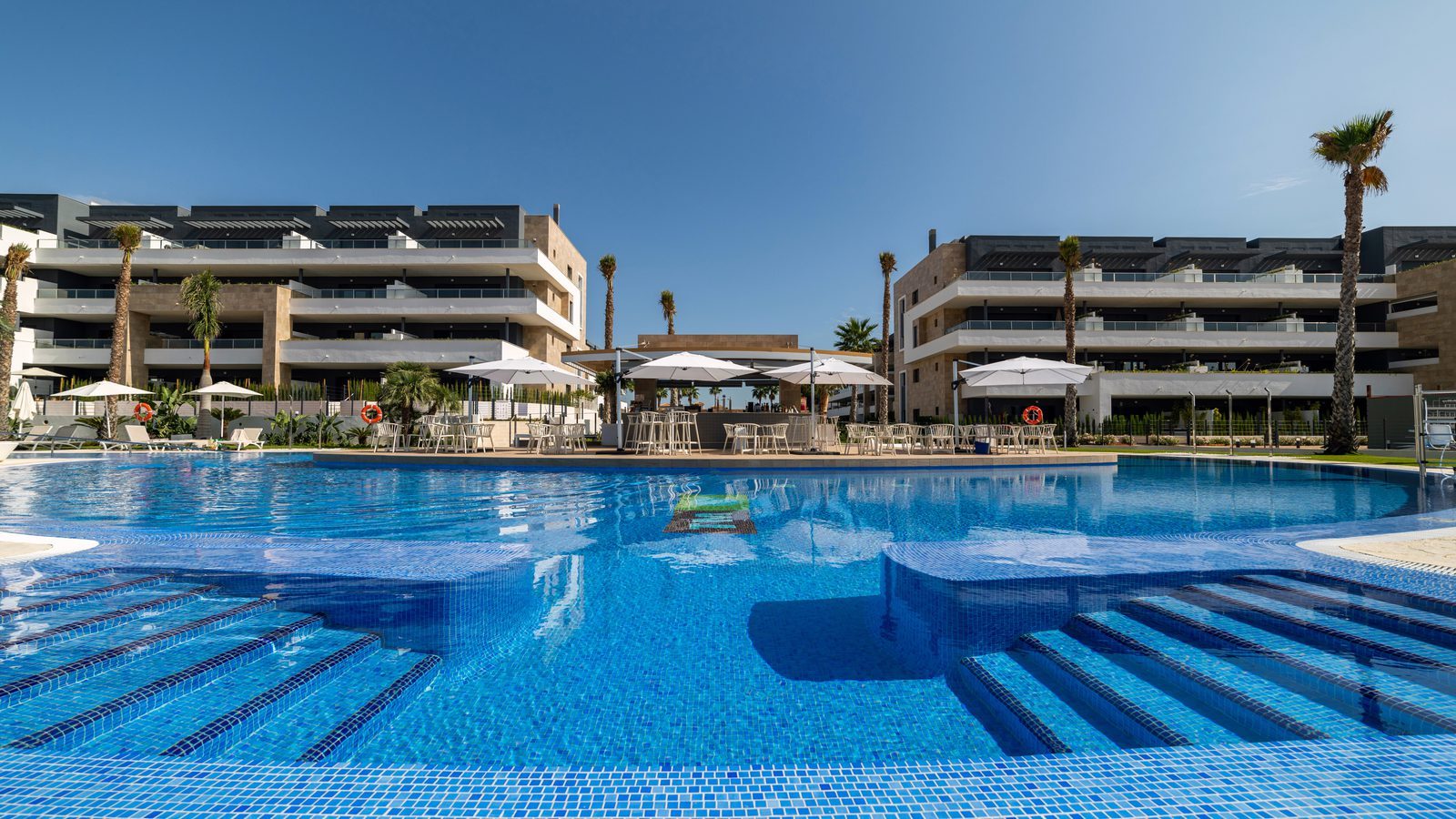Large communal pool and modern apartment buildings of a 3-bedroom apartment in Orihuela - The Estates