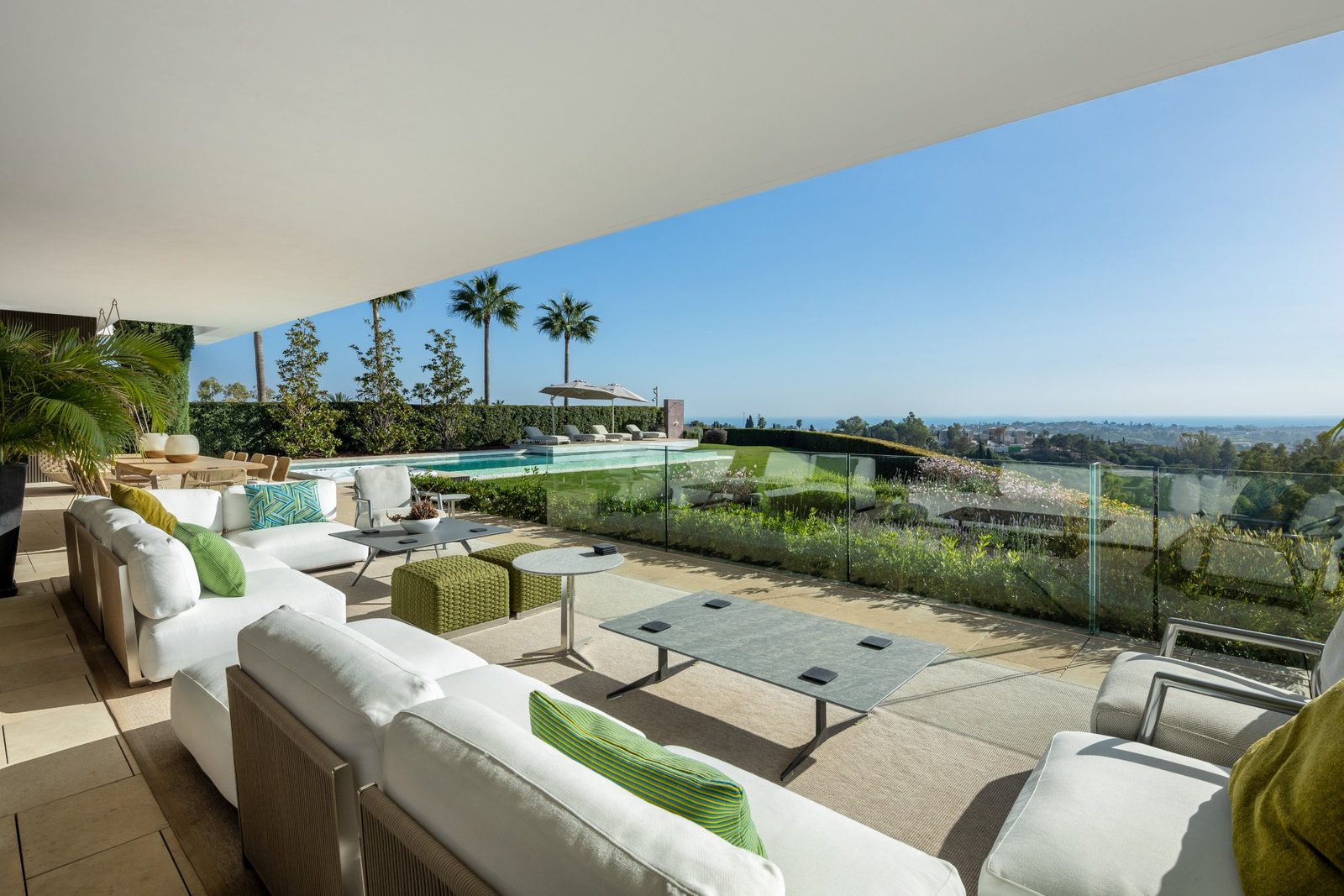 Covered outdoor lounge with pool and panoramic sea views at a 6-bedroom villa in Málaga - The Estates