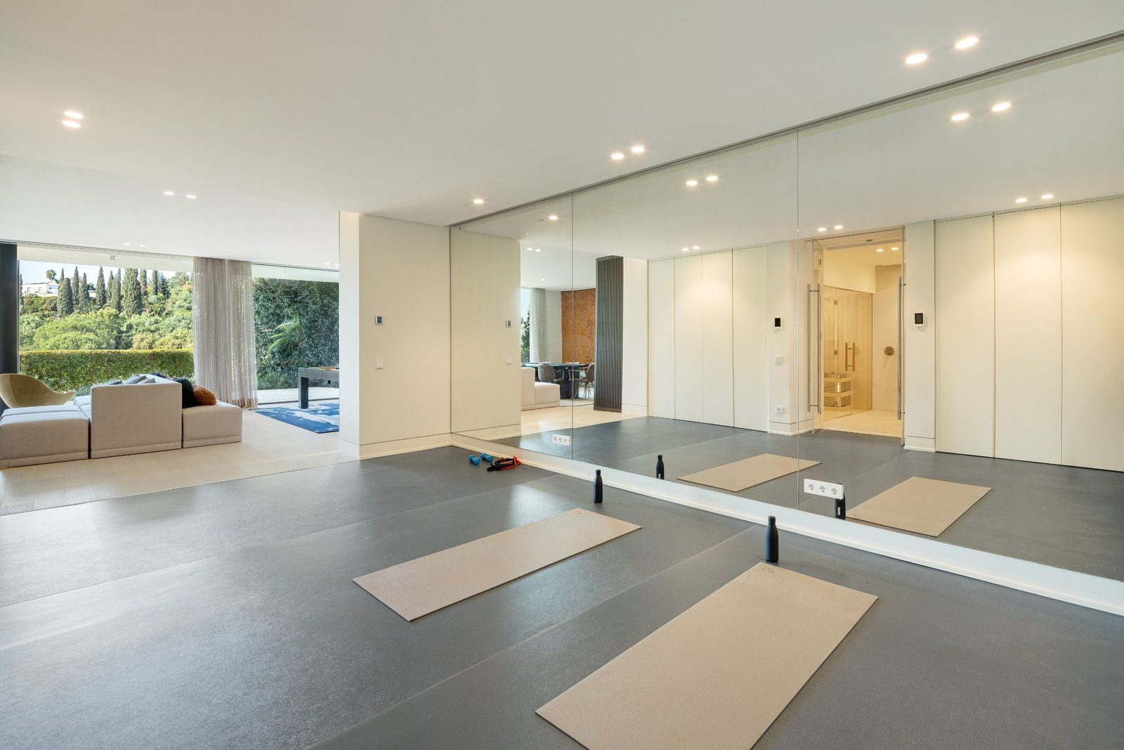 Mirrored home gym with yoga mats and garden views of a 6-bedroom villa in Málaga - The Estates