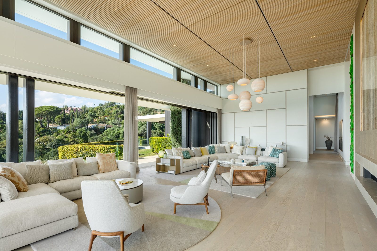 Spacious living room with floor-to-ceiling windows and garden views of a 6-bedroom villa in Málaga - The Estates