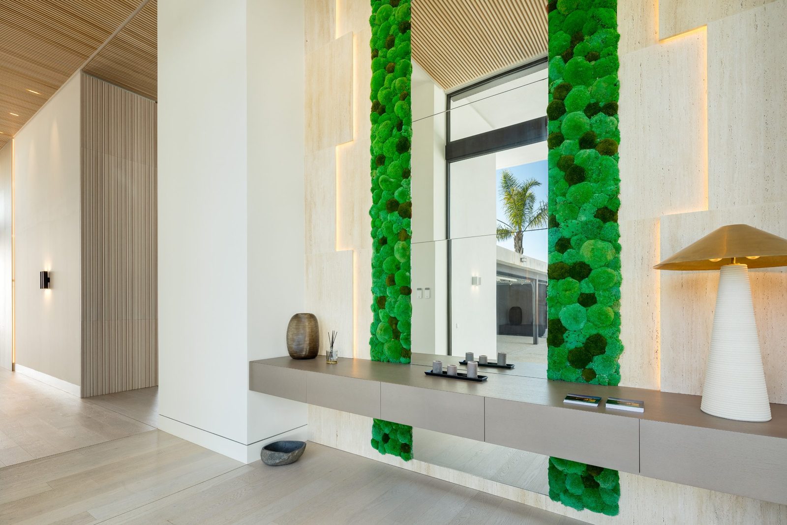 Modern entrance hall with console, mirror and green moss wall of a 6-bedroom villa in Málaga - The Estates