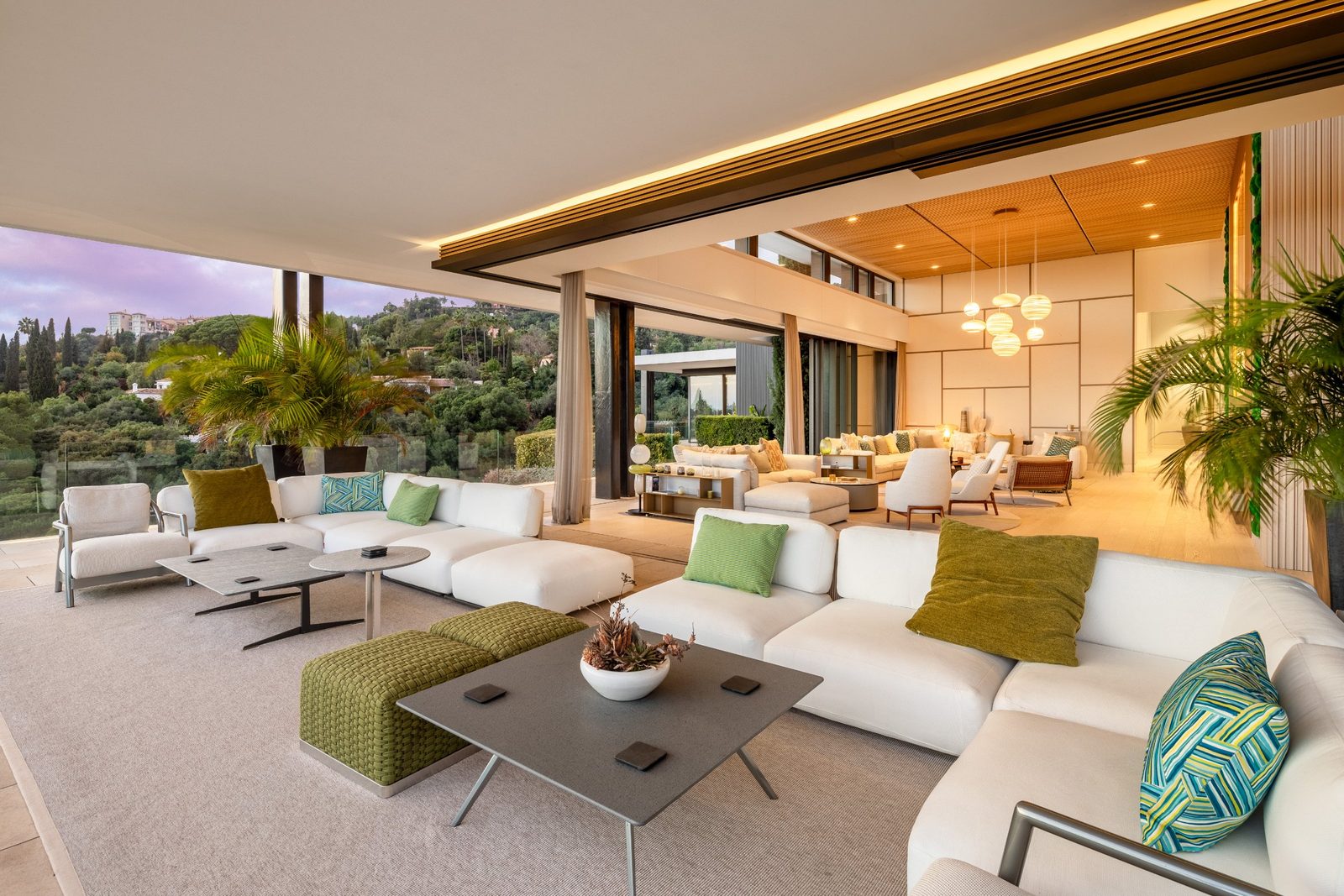 Open-plan lounge and covered terrace with garden views of a