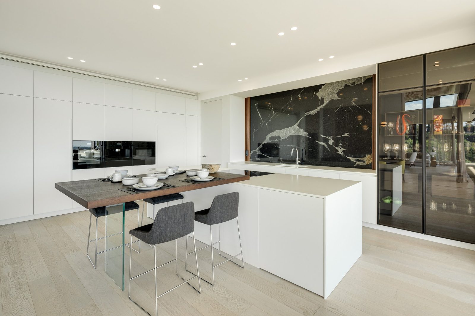Modern kitchen with marble backsplash, island and breakfast bar of a 6-bedroom villa in Málaga - The Estates