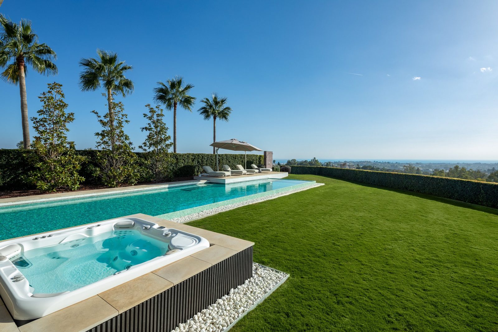 Pool and hot tub with manicured lawn, palms and sea views at a 6-bedroom villa in Málaga - The Estates