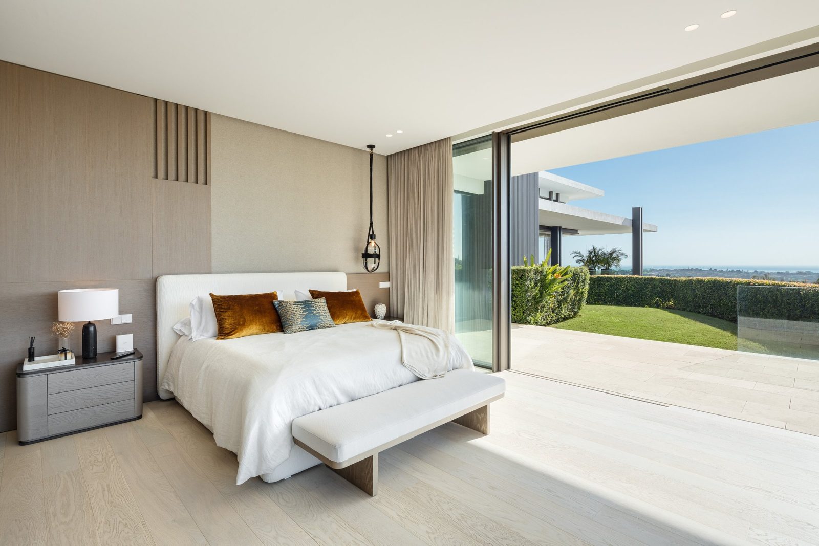 Modern bedroom opening onto a garden with panoramic sea views