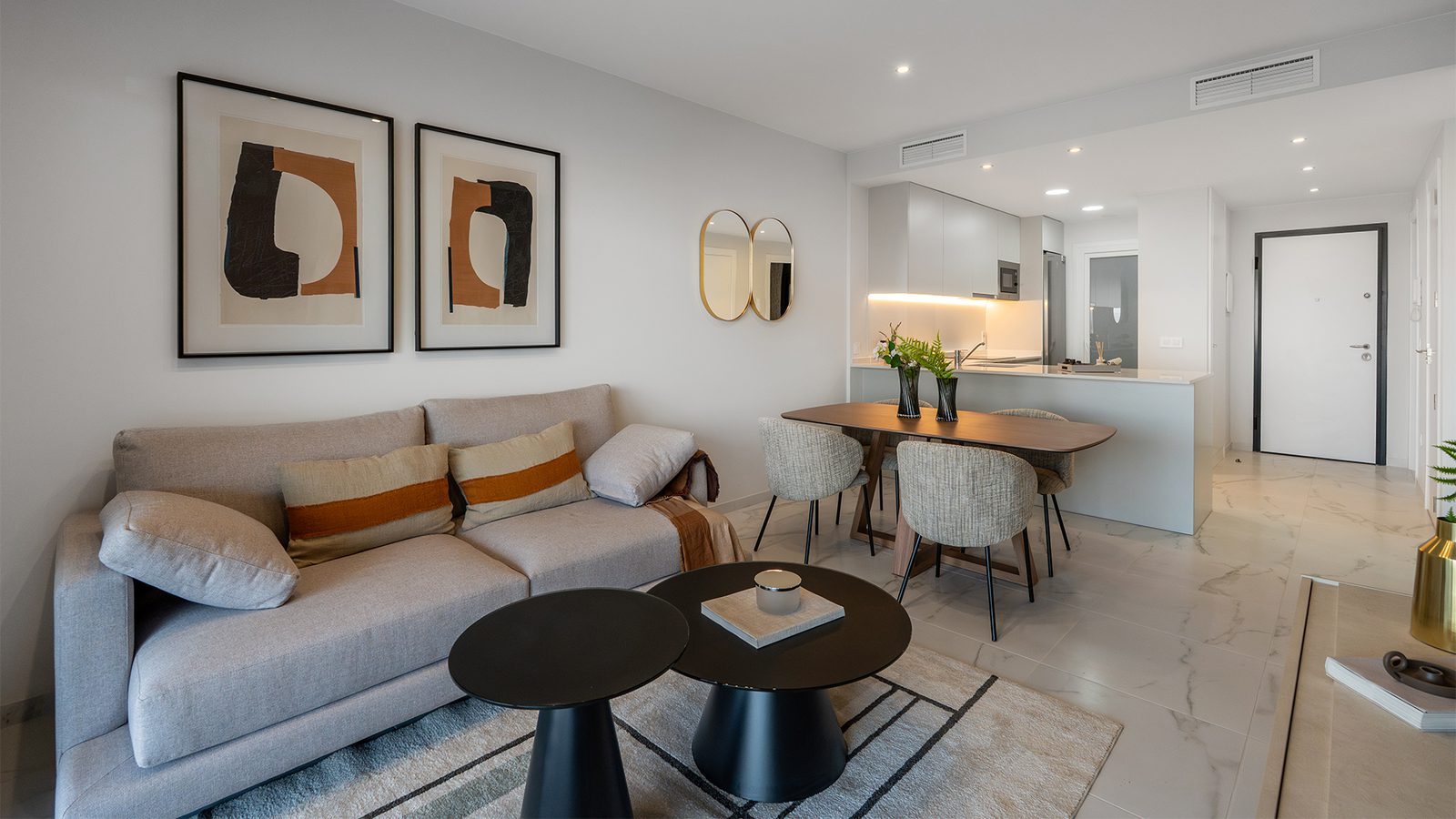 Modern living room with sofa, coffee tables, dining area and open kitchen in a 3-bedroom apartment in Torrevieja - The Estates