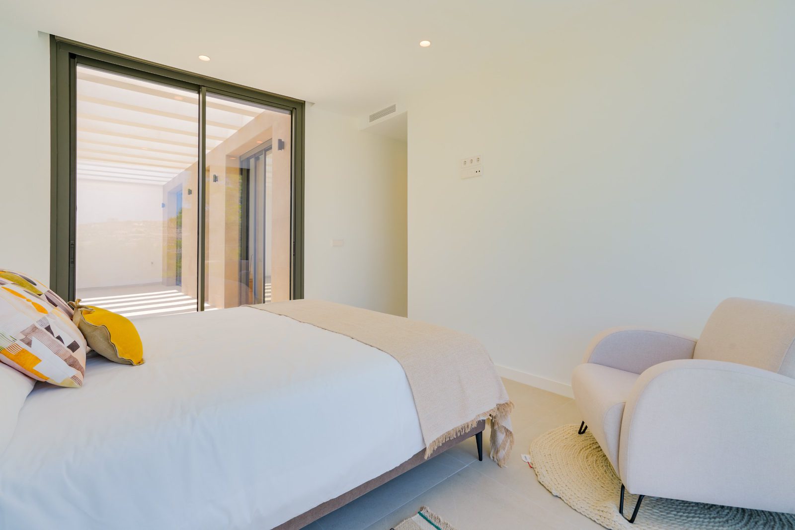 A bright bedroom with large windows overlooking countryside views of a 4-bedroom villa in Moraira - The Estates