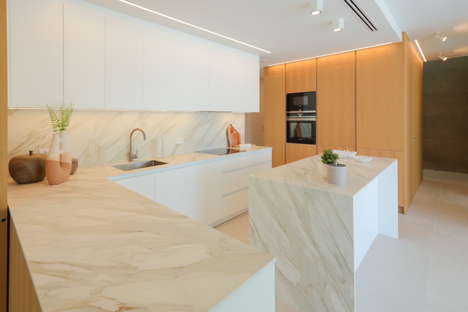 Modern kitchen with marble countertops and wooden cabinetry in a 4-bedroom villa in Moraira - The Estates