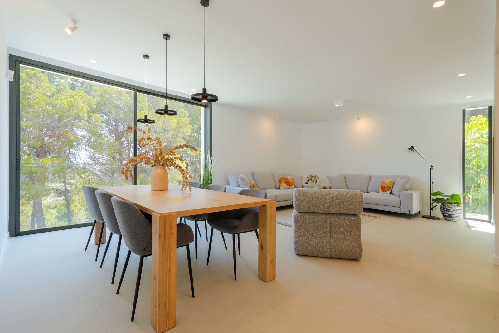 Bright living and dining area with large windows overlooking countryside views of a 4-bedroom villa in Moraira - The Estates