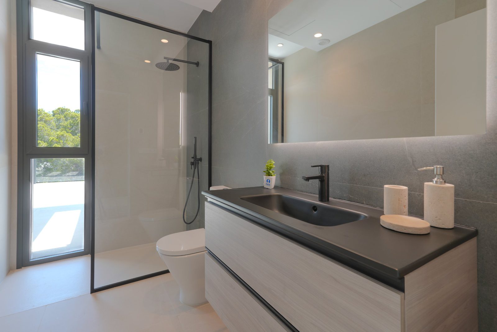 A modern bathroom with a walk-in shower and vanity in a 4-bedroom villa in Moraira - The Estates