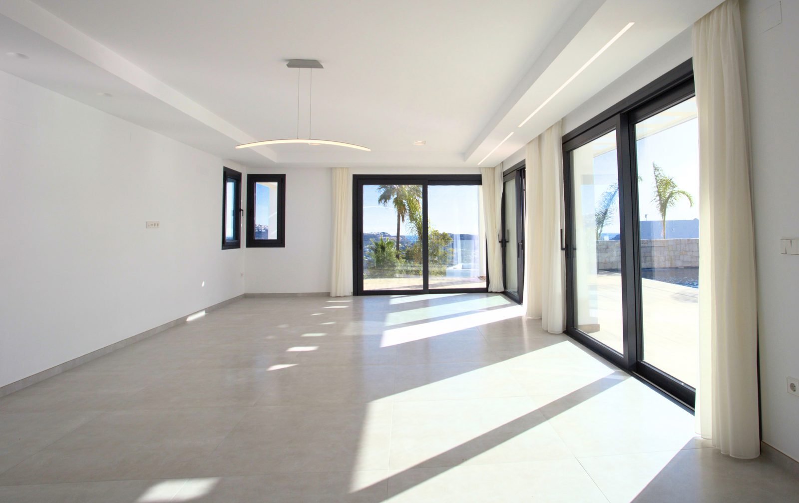 Bright living room with large windows and sea views in a 3-bedroom villa in Moraira - The Estates