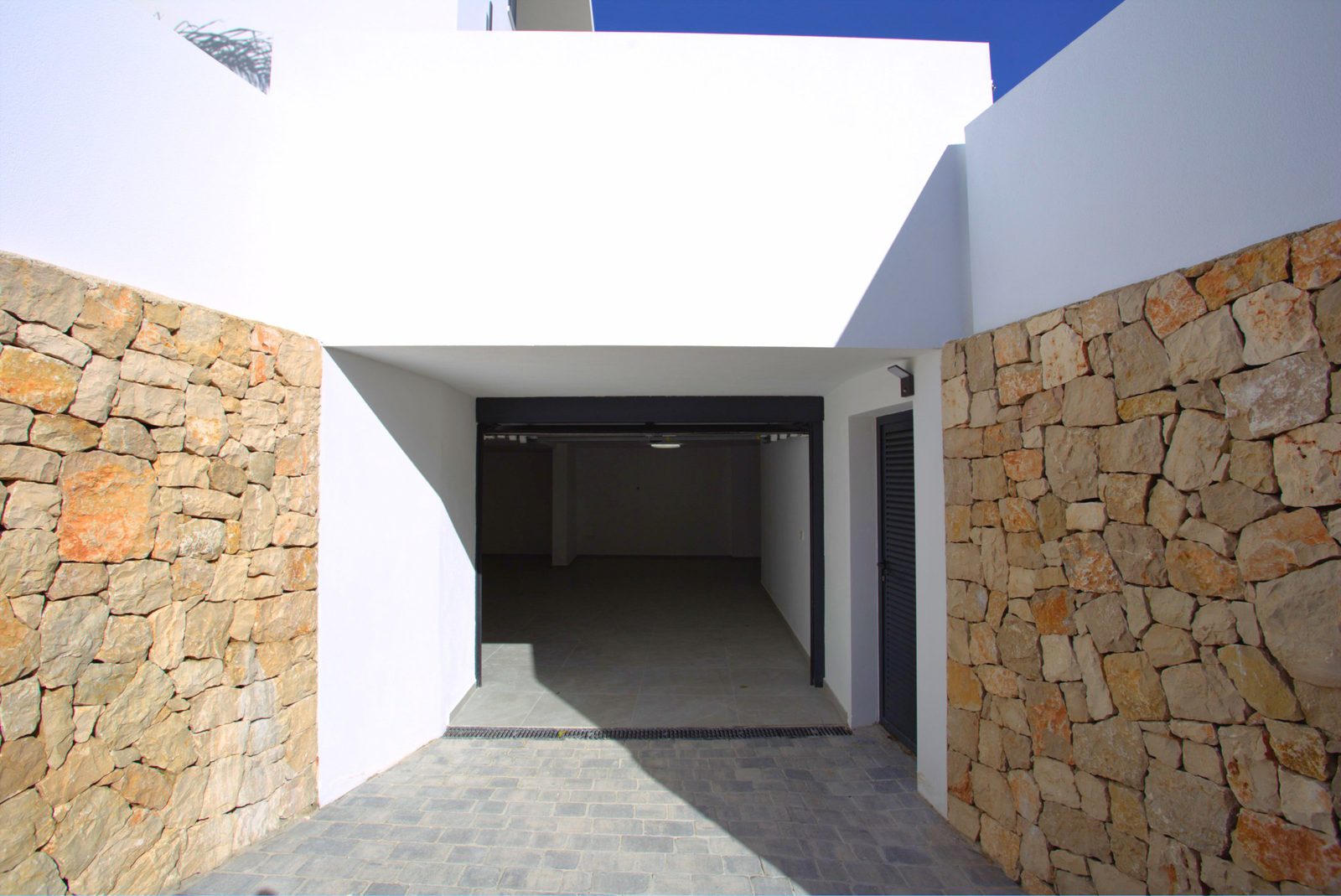 Modern villa architecture with stone accents and a spacious interior - The Estates