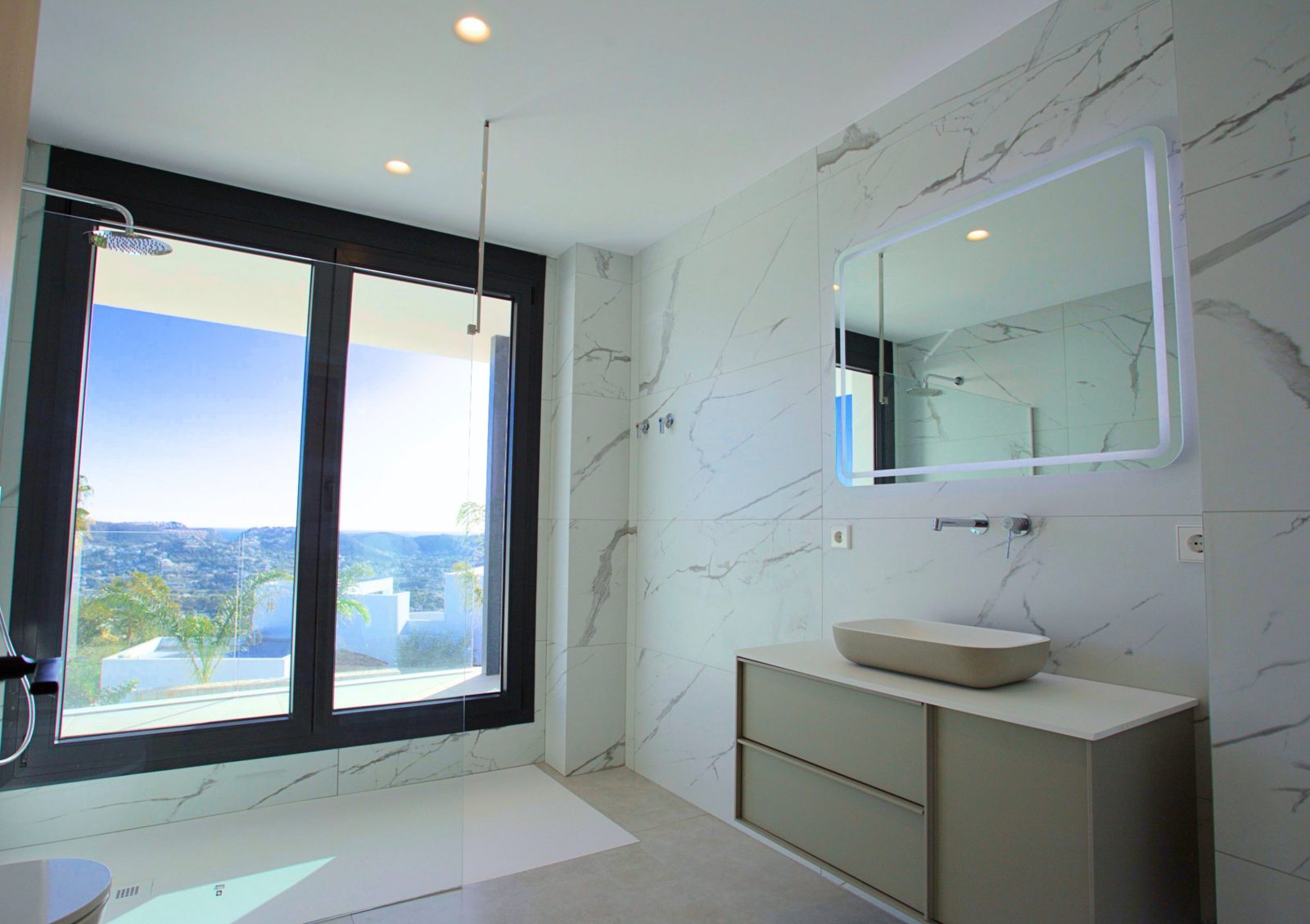 Stylish bathroom with marble tiling, a modern vanity, and stunning sea views in a 3-bedroom villa in Moraira - The Estates