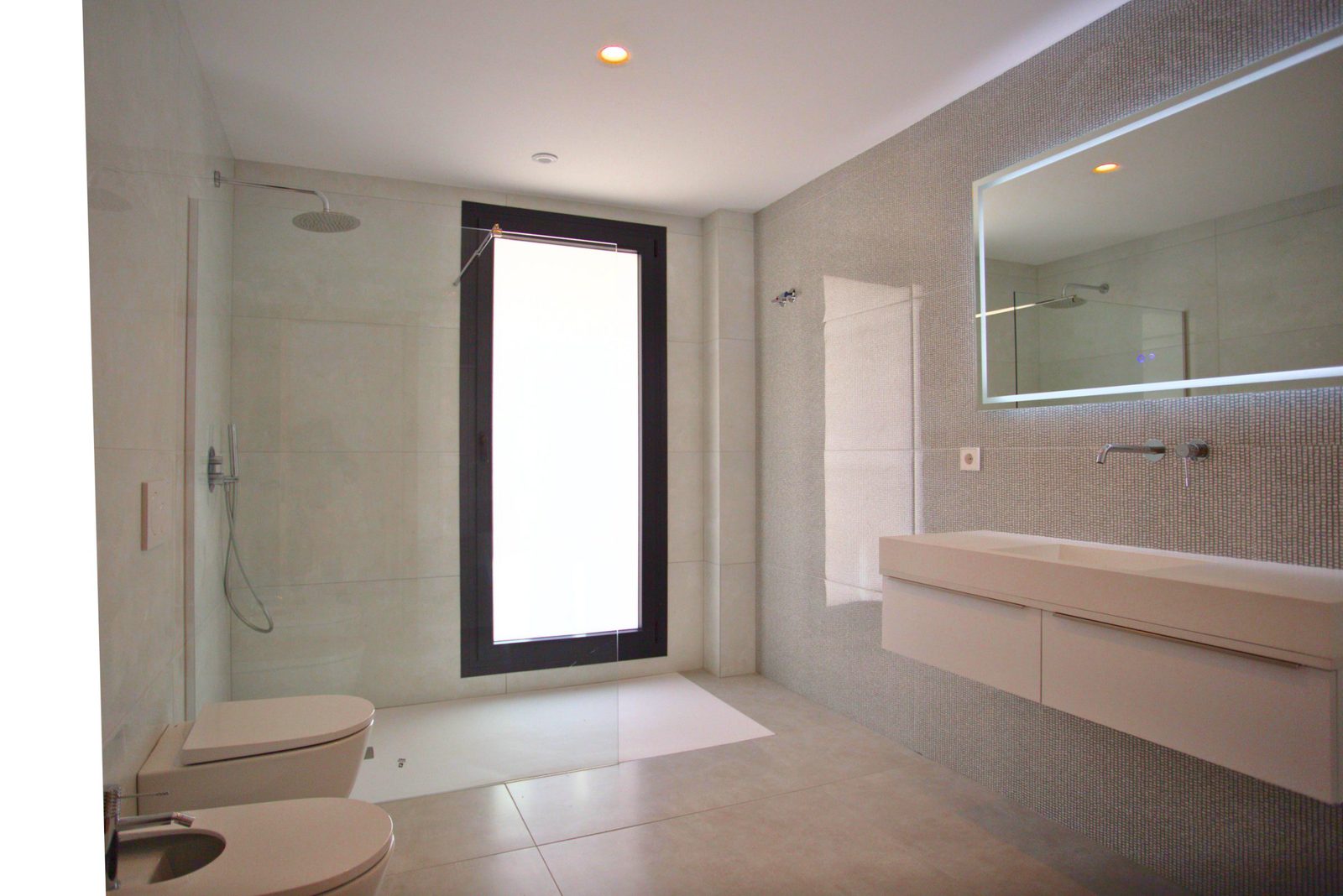 Modern bathroom with walk-in shower and window in a 3-bedroom villa in Moraira - The Estates