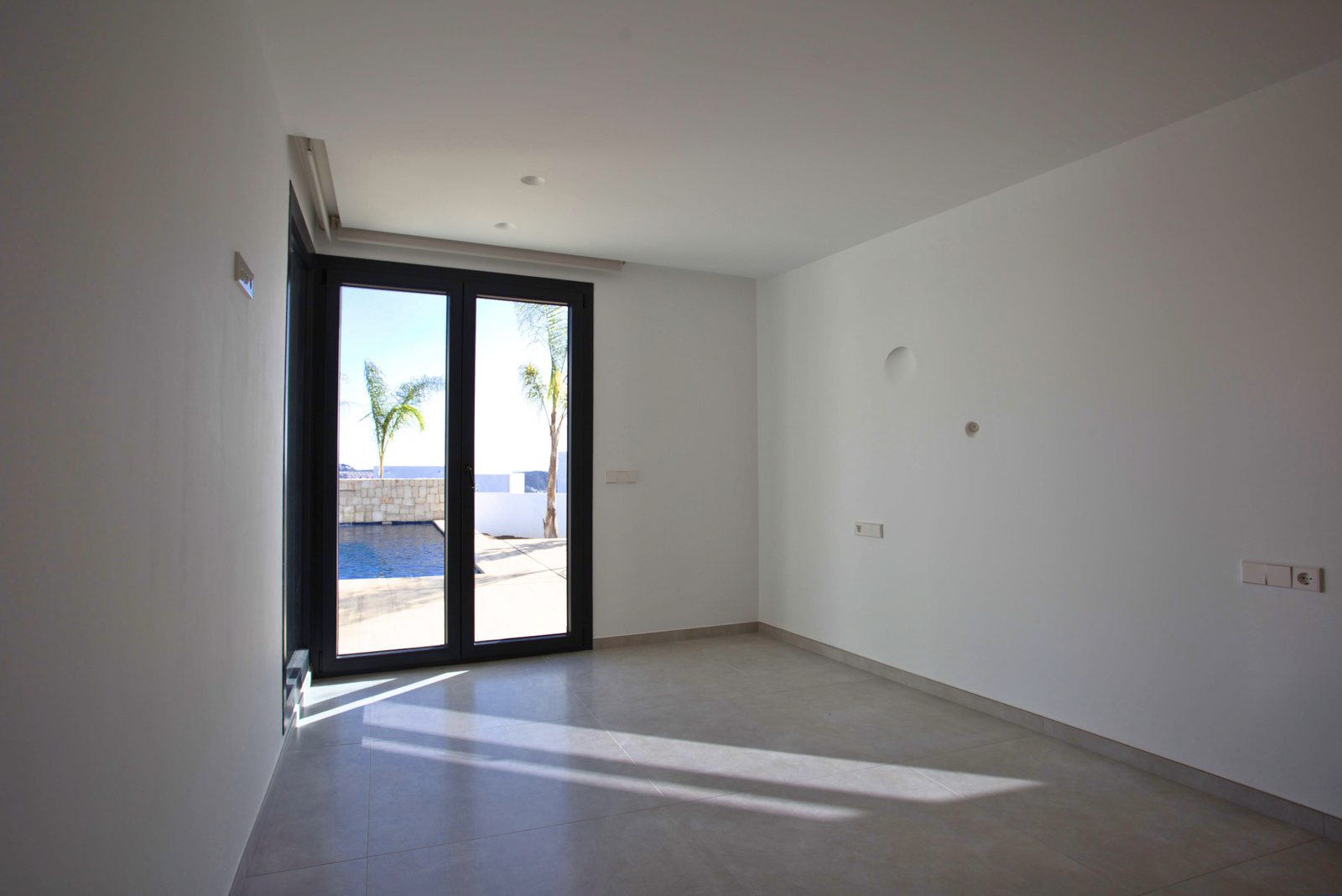 Bright living room with patio doors and sea views in a 3-bedroom villa in Moraira - The Estates
