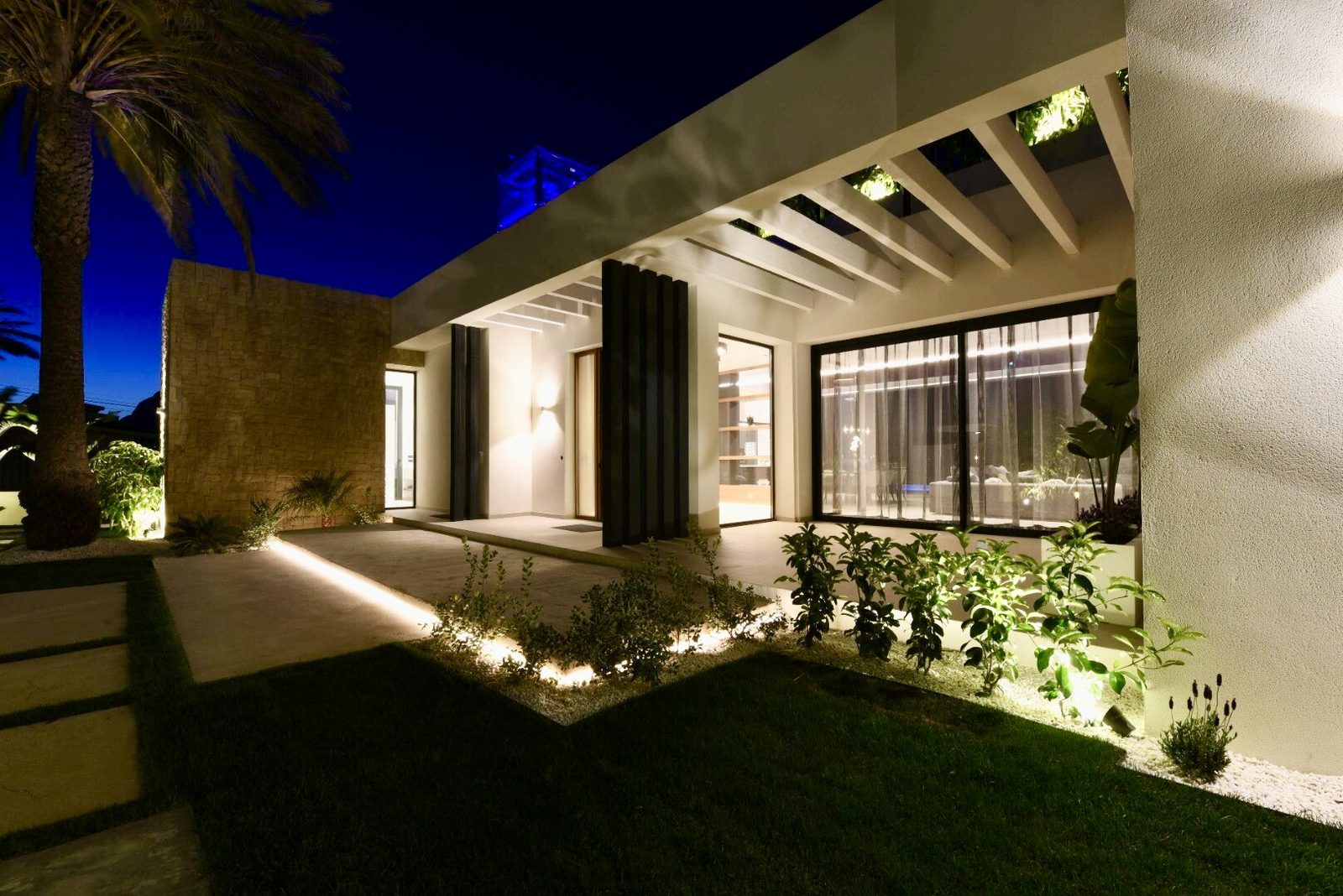 Elegant exterior of a 4-bedroom villa in La Nucia, showcasing modern architecture and beautiful night views - The Estates