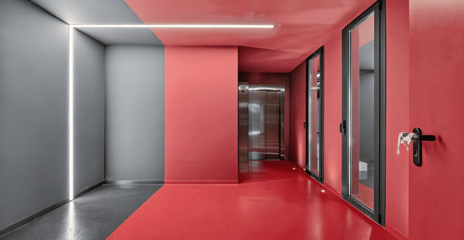 Modern hallway with red and gray walls and a glass door in a 4-bedroom villa in La Nucia - The Estates