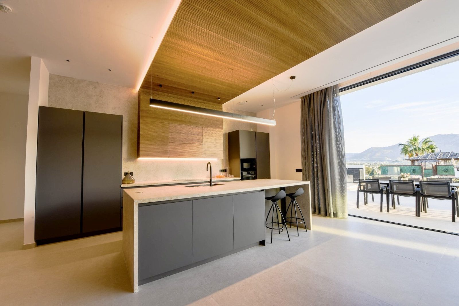 Modern kitchen with island and views of the terrace of a 4-bedroom villa in La Nucia - The Estates
