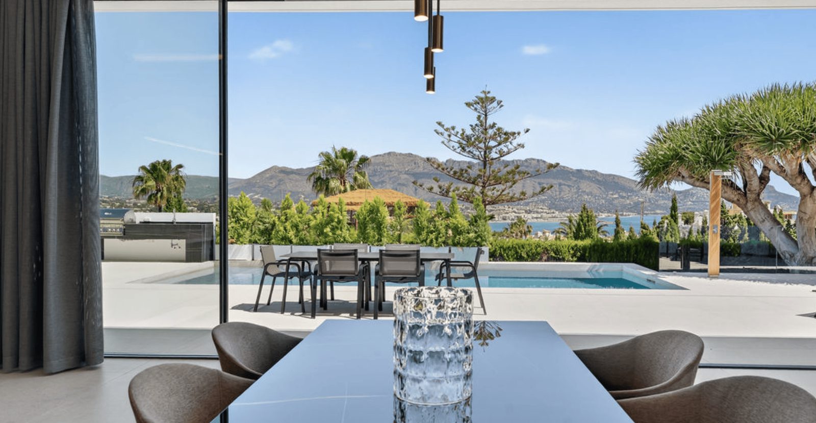A dining area with stunning sea and city views from a 4-bedroom villa in La Nucia - The Estates