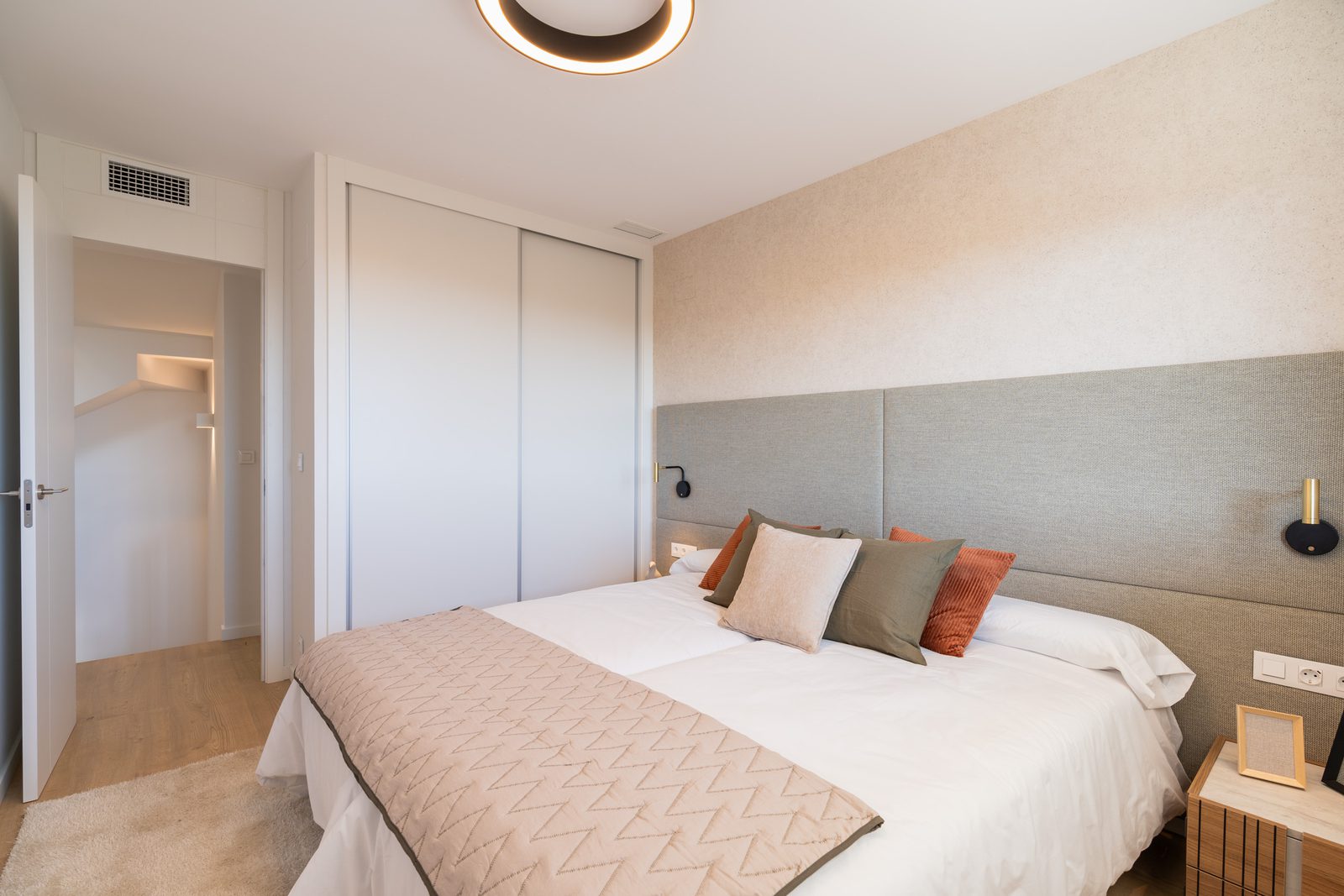 A modern bedroom with built-in wardrobes and stylish decor in a 4-bedroom townhouse in La Nucía - The Estates