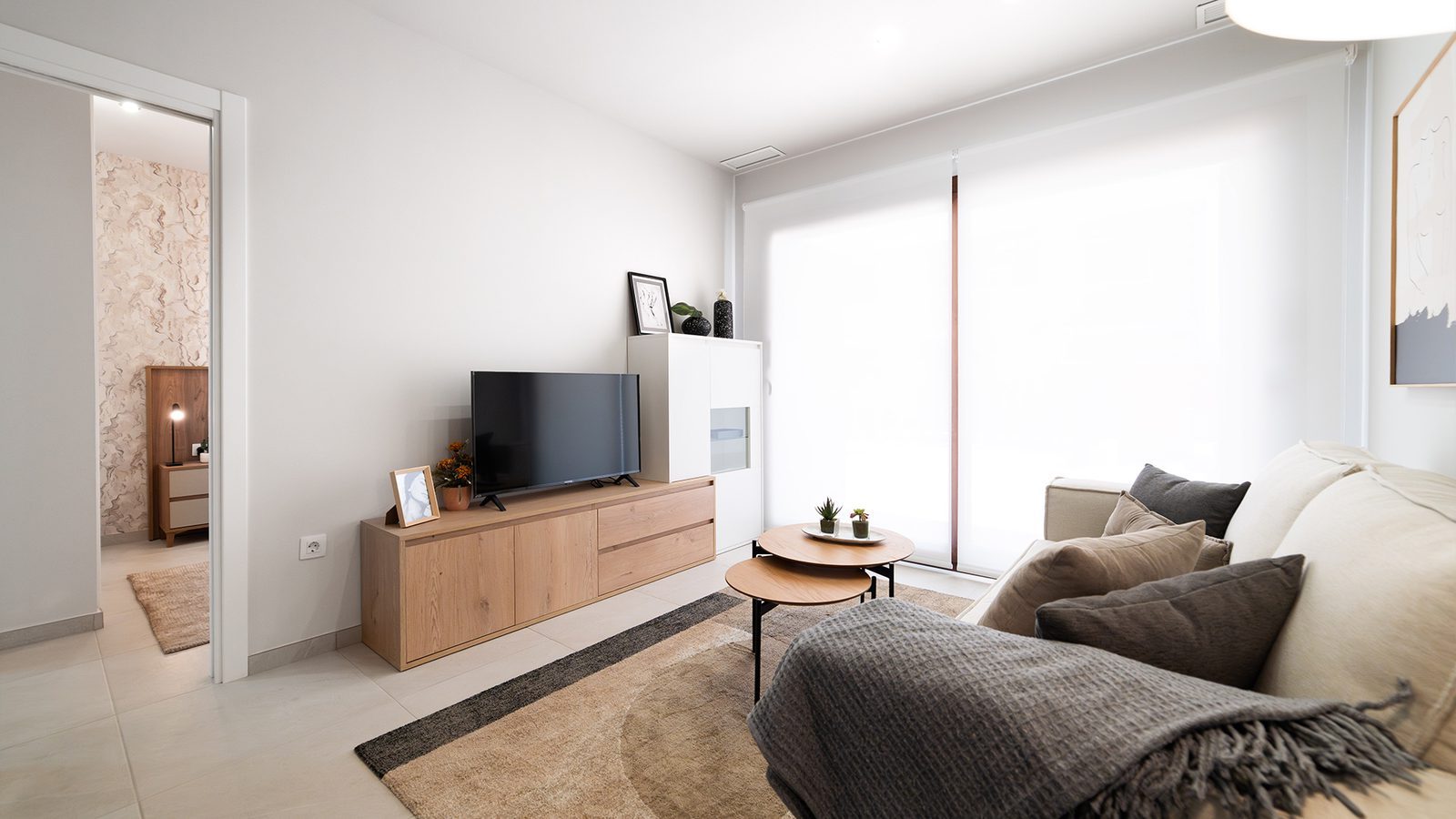 Bright living room with sofa, TV unit, coffee tables and large windows in a 3-bedroom bungalow in Pulpí - The Estates