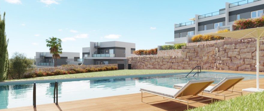 Communal swimming pool and sun loungers beside modern villas in Finestrat - The Estates