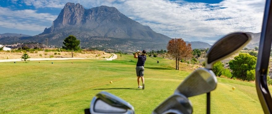 Golf course with a golfer and mountain views near a 4-bedroom villa in Finestrat - The Estates