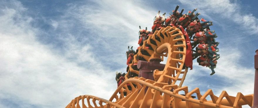 Orange roller coaster with riders against a blue sky, shown in a 4-bedroom villa in Finestrat - The Estates