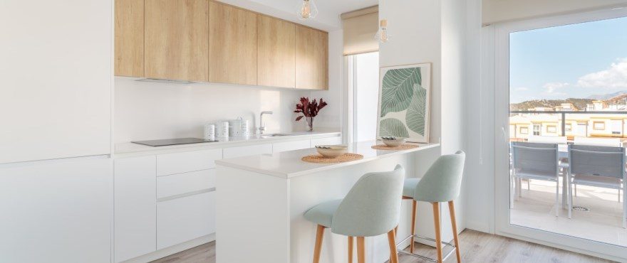 Bright open-plan kitchen with breakfast island and terrace views of a 4-bedroom villa in Finestrat - The Estates