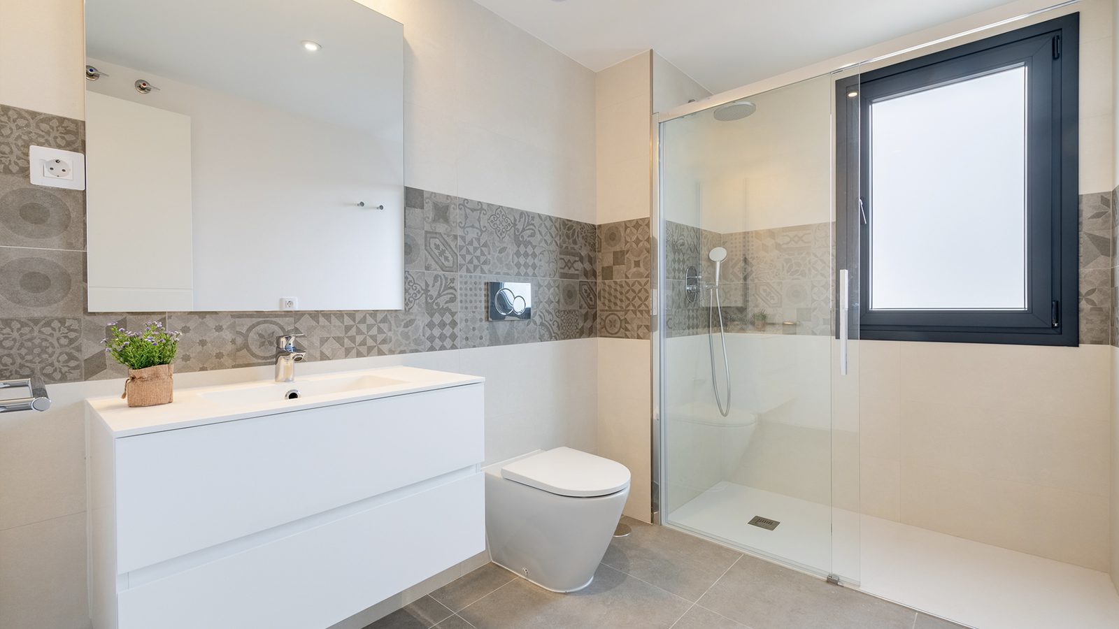 A modern bathroom with patterned tiles and a walk-in shower in a 3-bedroom semi-detached in Capdepera - The Estates