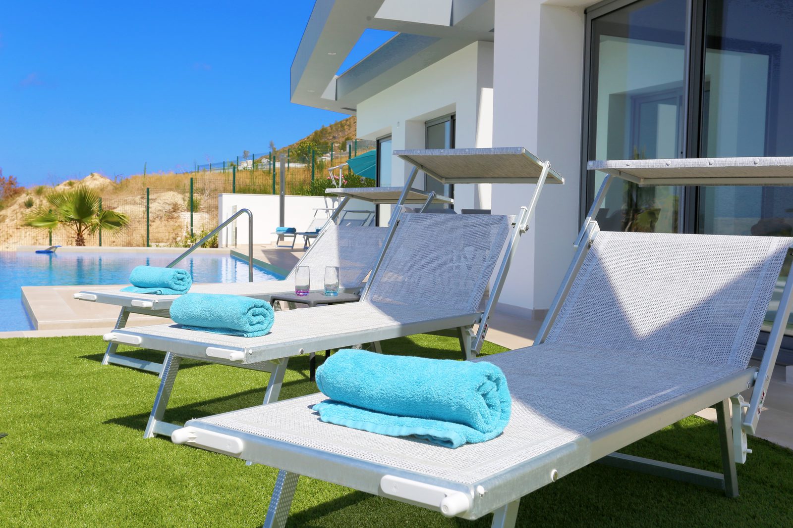 A pool and sun loungers with a sea view at a 4-bedroom chalet in Javea - The Estates
