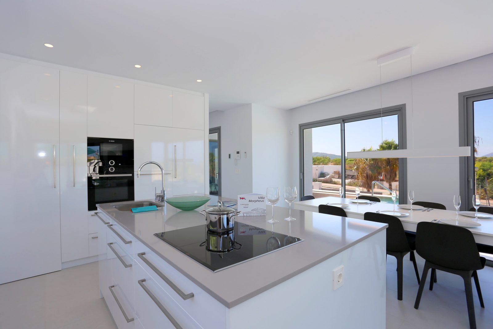 Modern kitchen with island and dining area in a 4-bedroom chalet in Javea - The Estates