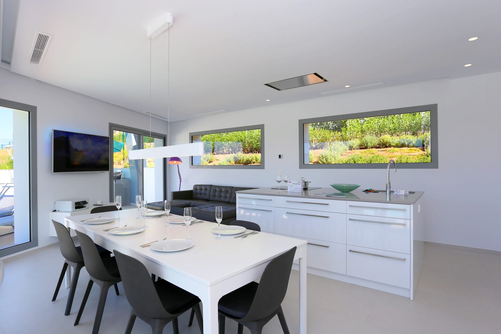 Modern kitchen and dining area with large windows and sea views in a 4-bedroom chalet in Javea - The Estates