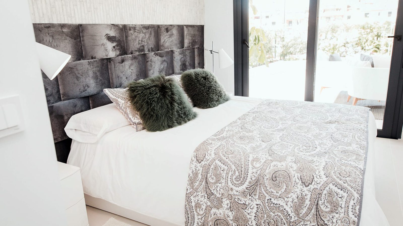 A stylish bedroom with a textured headboard and decorative pillows in a 2-bedroom apartment in Estepona - The Estates