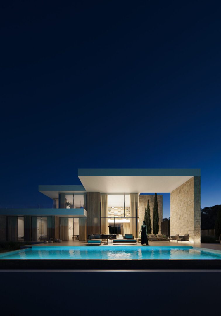 Modern villa exterior with illuminated pool at dusk in Moraira - The Estates