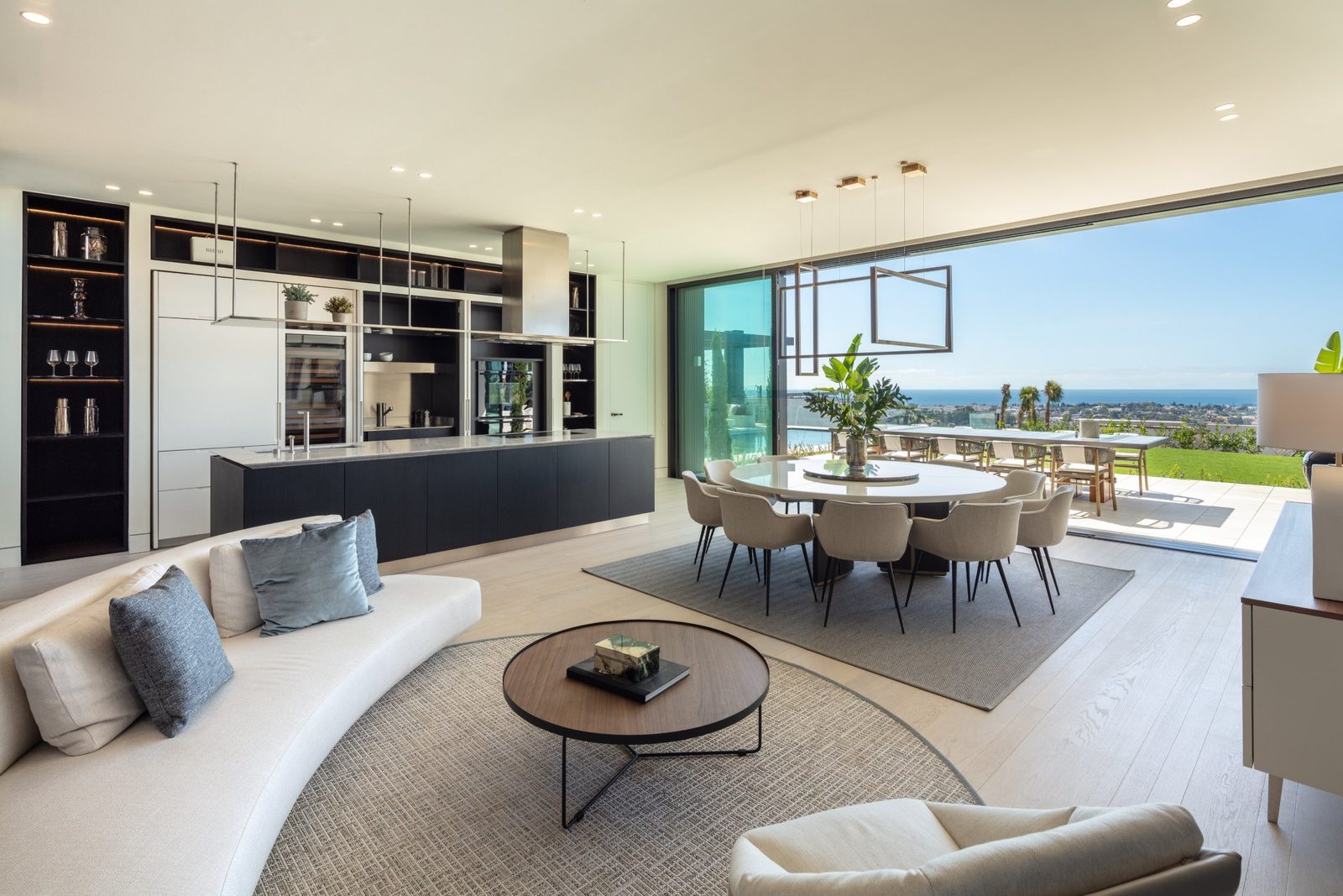 Open-plan living, dining and kitchen with panoramic sea views of a 7-bedroom villa in Málaga - The Estates