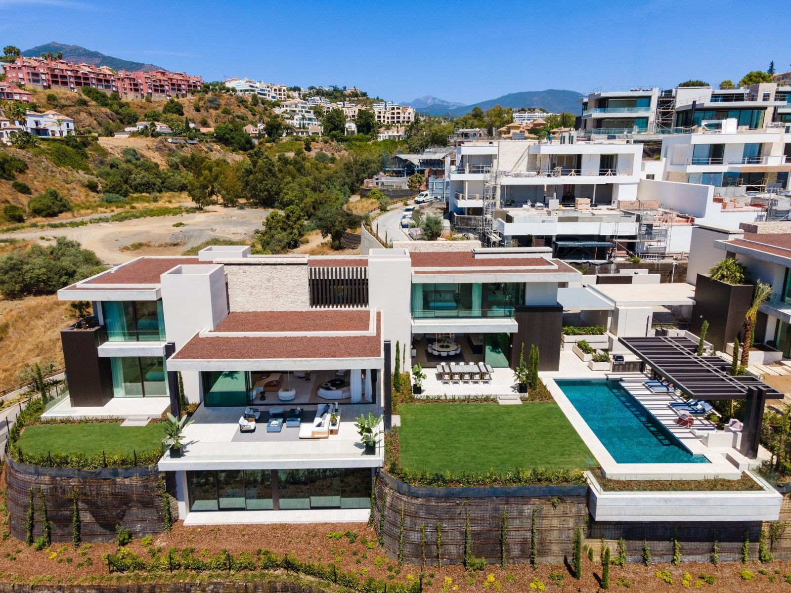 Aerial view of a modern villa with pool, gardens and panoramic mountain and sea views in Málaga - The Estates