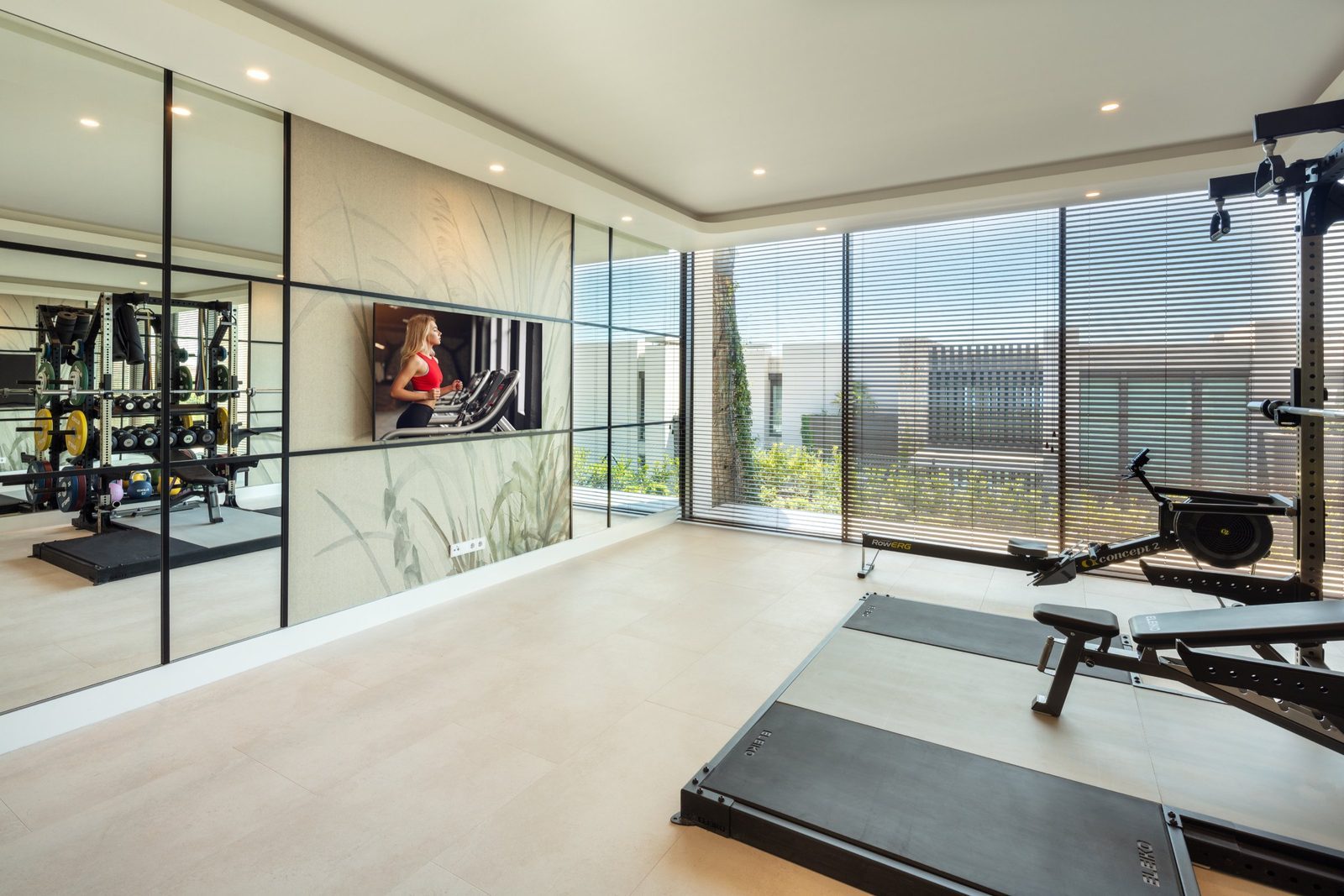 Modern home gym with treadmills, rowing machine, weights and mirrored walls in a 7-bedroom villa in Málaga - The Estates