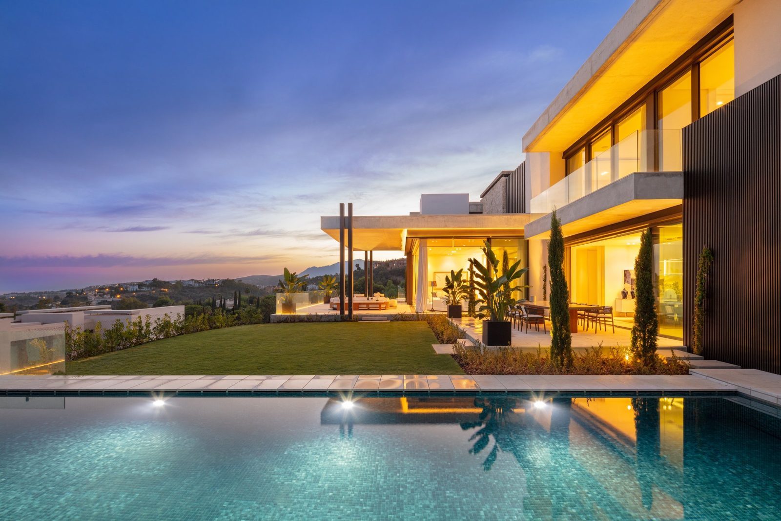 Modern villa exterior with illuminated terraces, landscaped garden, pool and panoramic sea views of a 7-bedroom villa in Málaga - The Estates