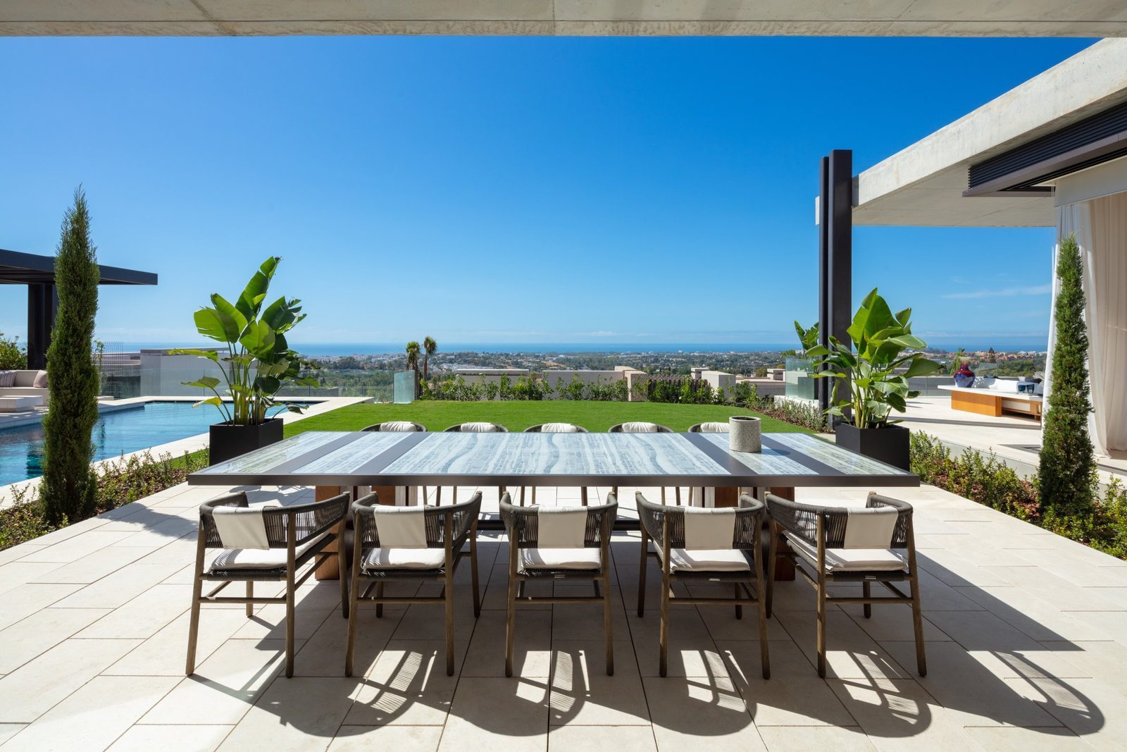 Outdoor dining terrace with pool and panoramic sea views of a 7-bedroom