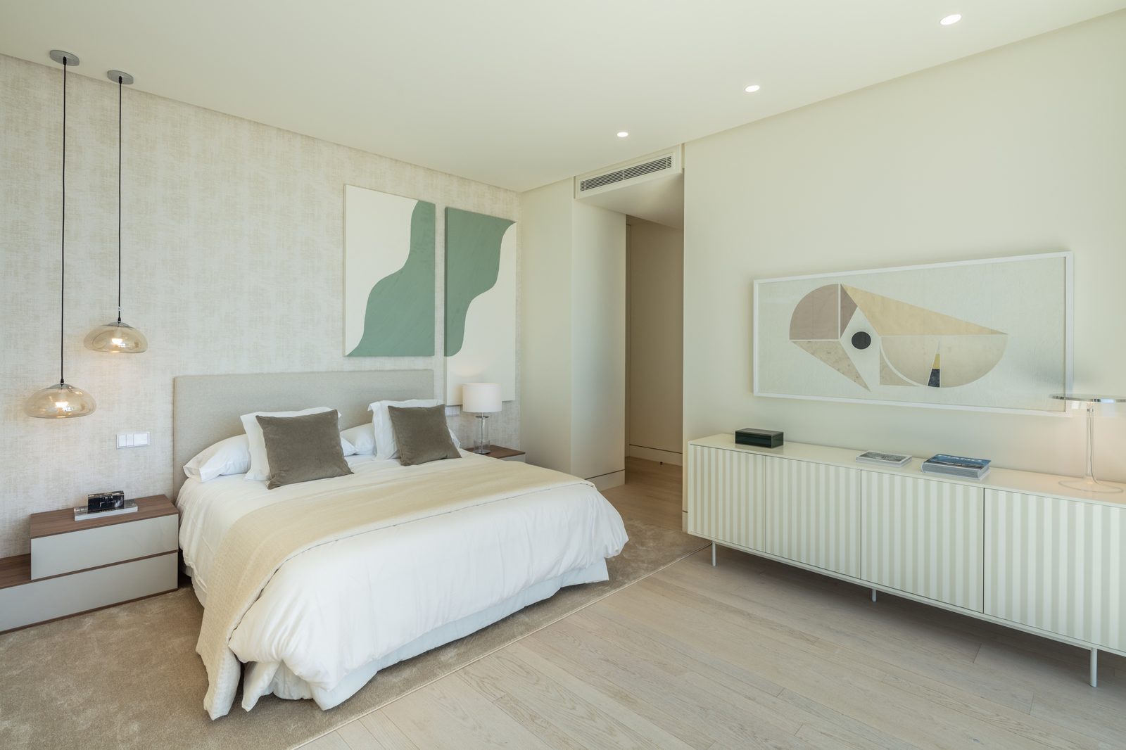 Modern bedroom with double bed, pendant lights, abstract artwork and designer sideboard of a 7-bedroom villa in Málaga - The Estates